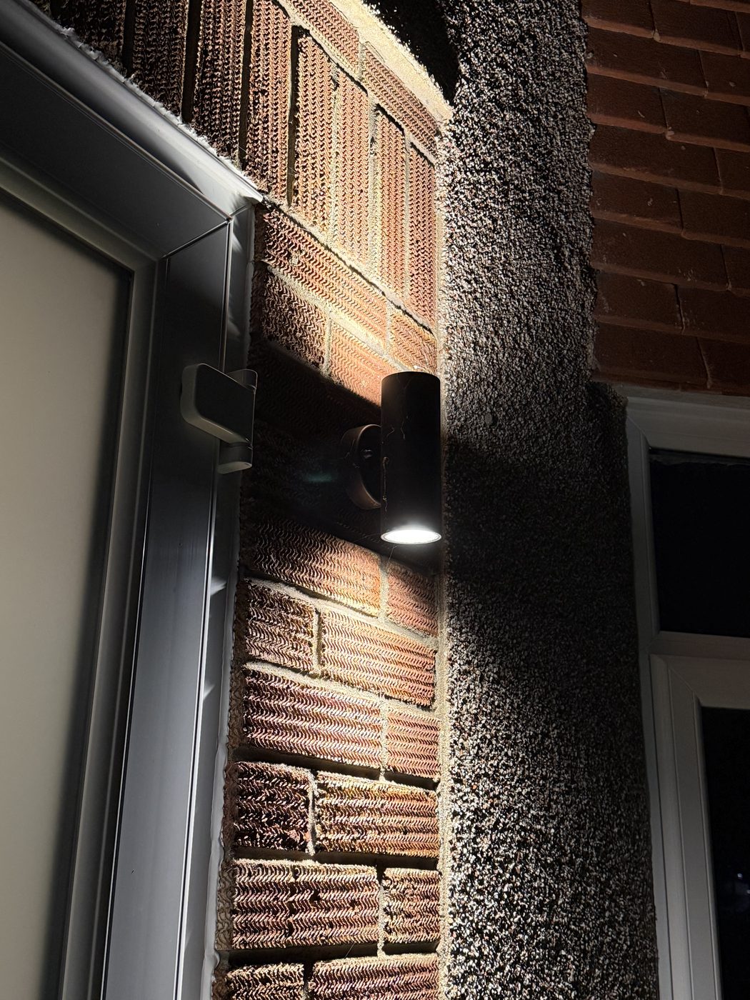An up-and-down exterior wall light on brickwork at night
